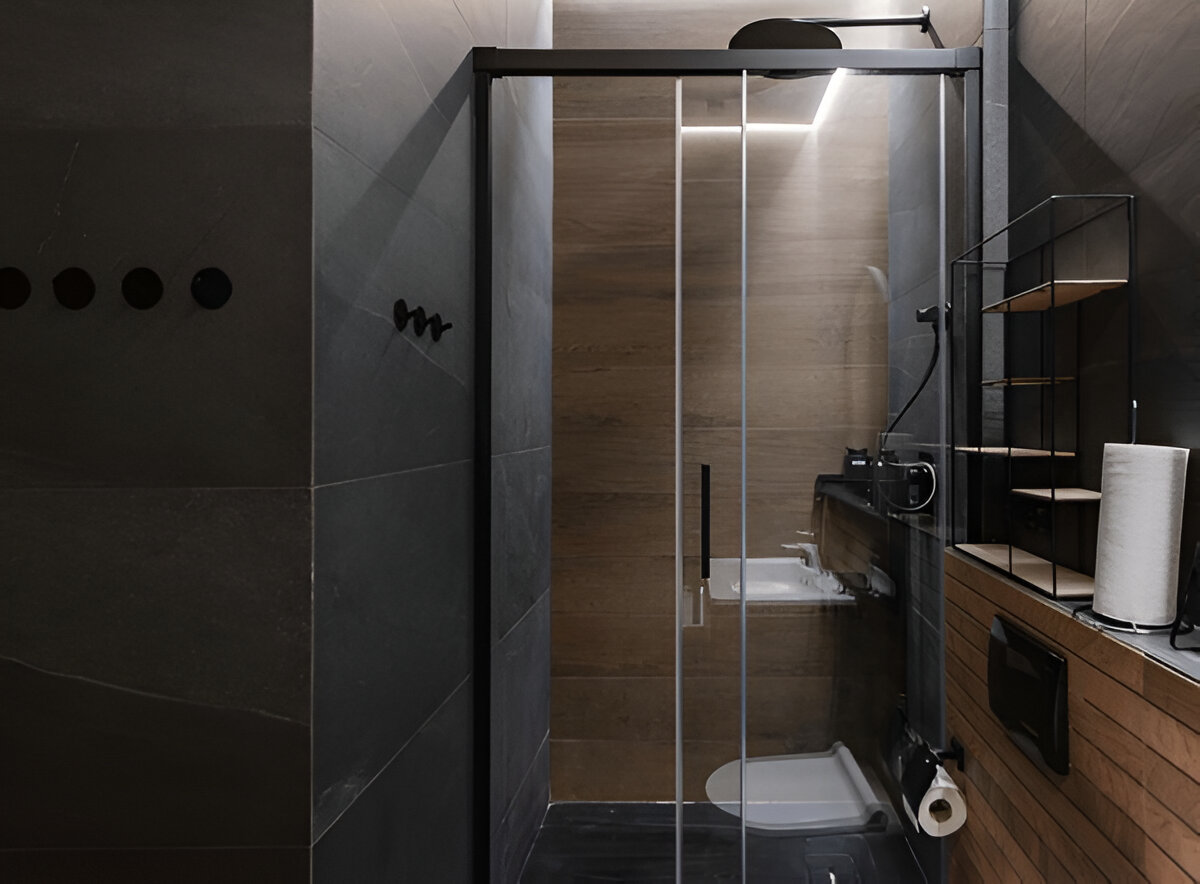 Minimalist bathroom with glass shower enclosure and wood accents