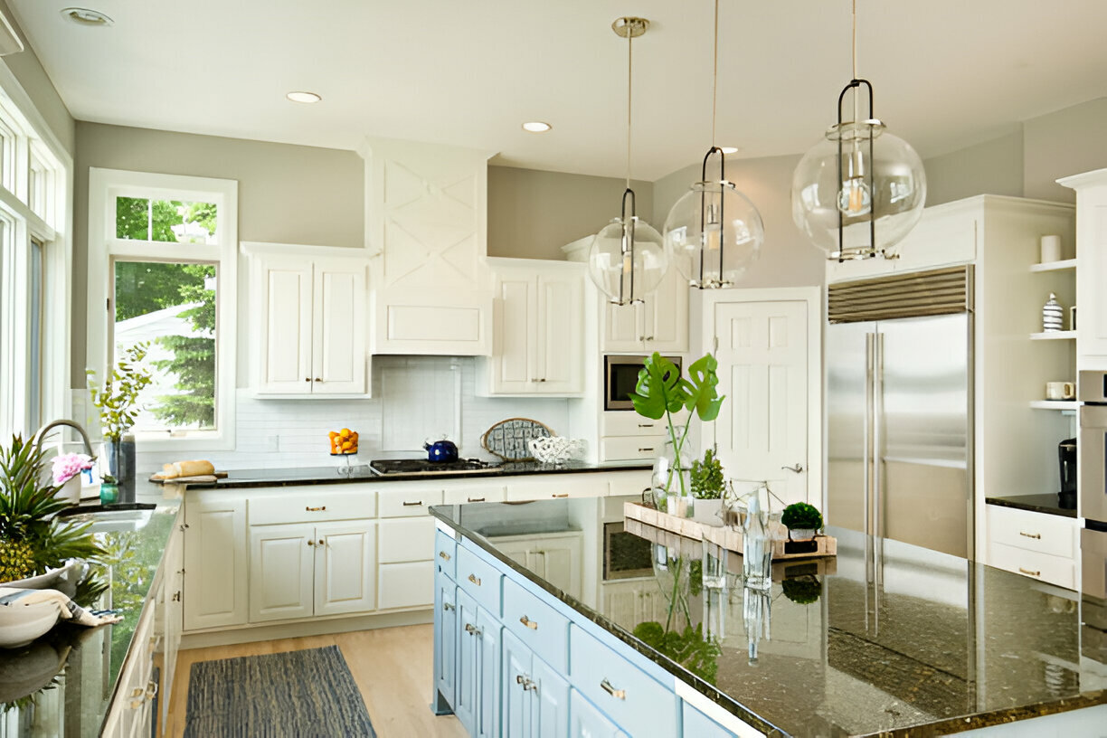 Bright kitchen with white cabinets, light blue island, and globe pendant lights