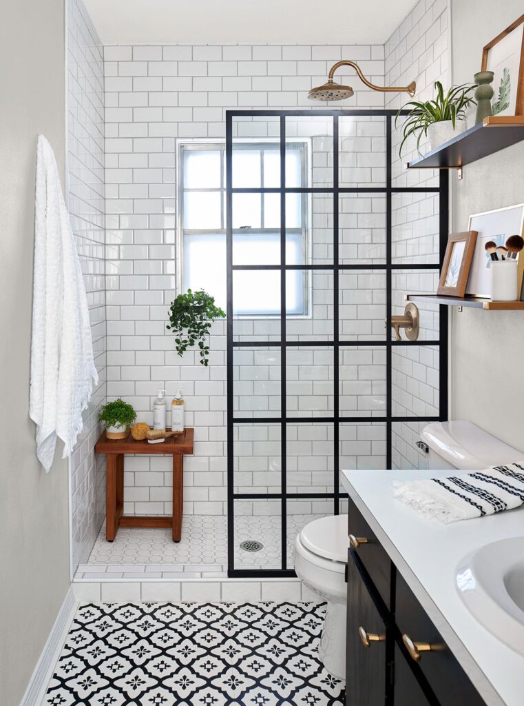 Smart Remodeling Solutions for Small Bathrooms 14 Compact bathroom with black grid shower glass, white subway tiles, patterned floor tiles, and green plants