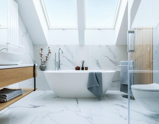 The image shows a stunning bathroom with a freestanding bathtub, a double vanity, and a glass-enclosed shower. The space is characterized by a sleek, modern design featuring extensive use of white marble and natural wood accents.