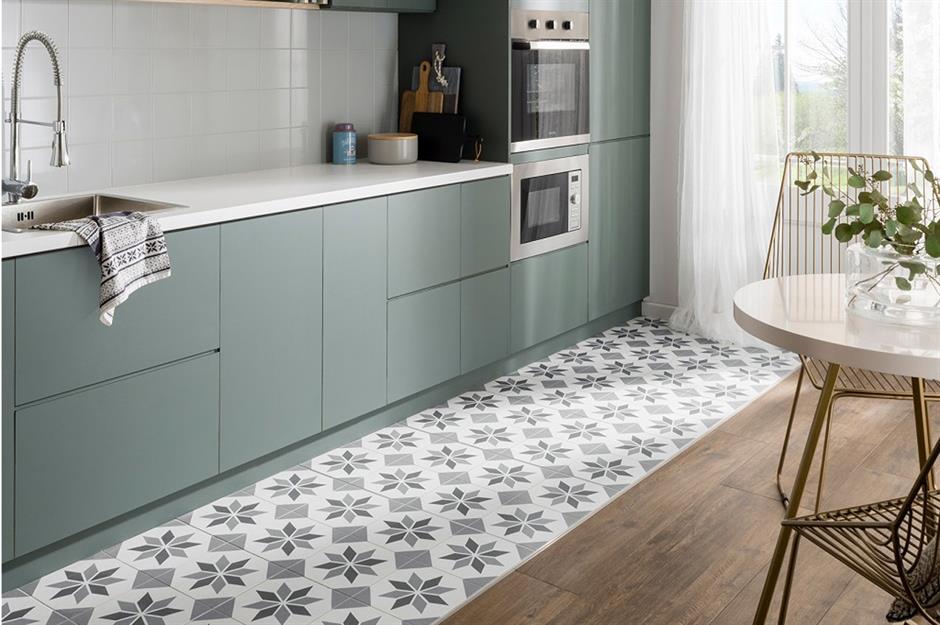 Creative Kitchen Floor Ideas 9 Modern kitchen featuring muted green cabinetry, white countertops, and a decorative patterned tile floor section creating a zoning effect within the wood floor layout.