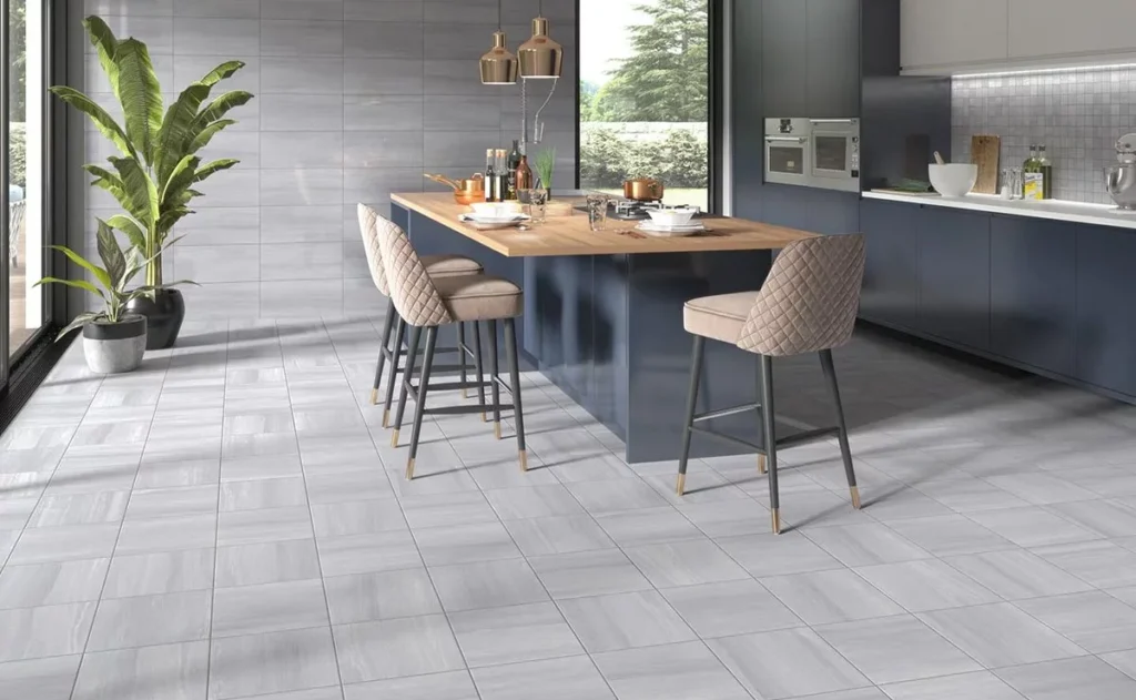 Best Kitchen Flooring Options 10 Contemporary kitchen with light gray ceramic tile flooring, navy cabinets, wooden island, and bar stools
