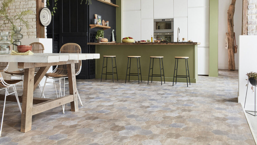 Best Kitchen Flooring Options 7 Open-plan kitchen with natural wood dining table, rattan chairs, and multi-toned hexagon tile flooring.