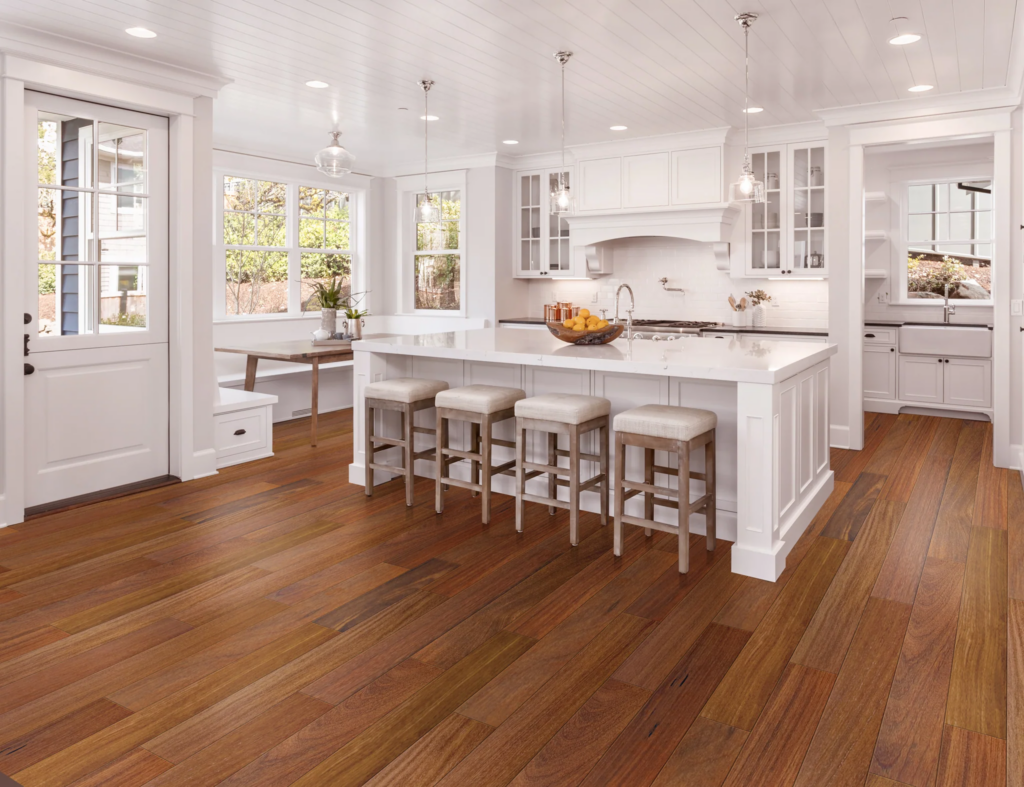 Best Kitchen Flooring Options 9 Modern kitchen with teak engineered wood flooring, white cabinetry, and a central island with bar stools