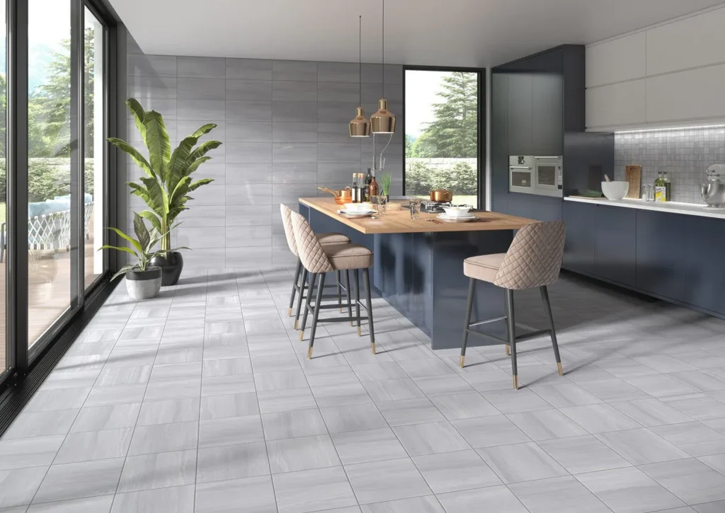 The Ultimate Guide to Kitchen and Floor Tiles 7 Contemporary kitchen interior featuring light gray ceramic floor tiles, a navy blue island with wooden countertop, and elegant beige bar stools