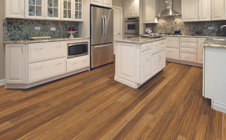 Top Kitchen Flooring Trends for 2025 11 Sustainable bamboo flooring in a modern kitchen with white cabinetry, granite countertops, and stainless steel appliances.