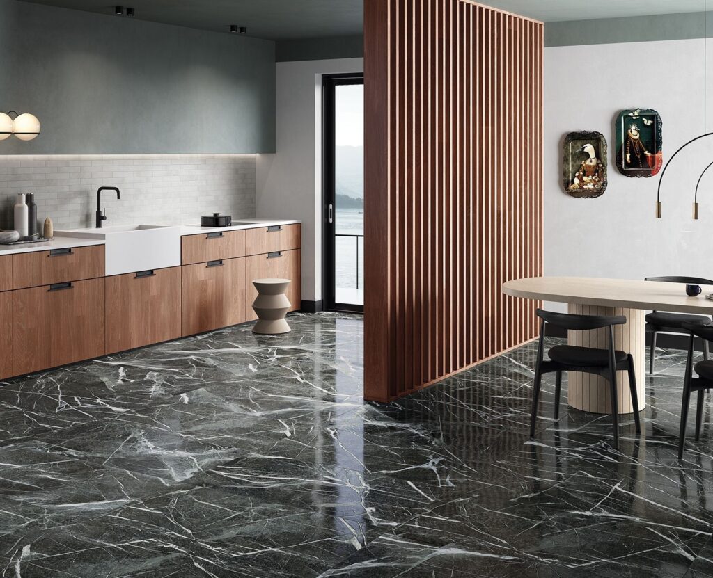 The Ultimate Guide to Kitchen and Floor Tiles 9 Stylish modern kitchen with dark marble flooring, minimalist wooden cabinetry, a farmhouse sink, and a contemporary dining area with a slatted wood room divider
