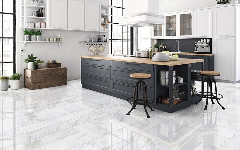 The Ultimate Guide to Kitchen and Floor Tiles 11 Contemporary kitchen with white and navy cabinets, glossy marble floor tiles, wooden countertops, and industrial-style bar stools