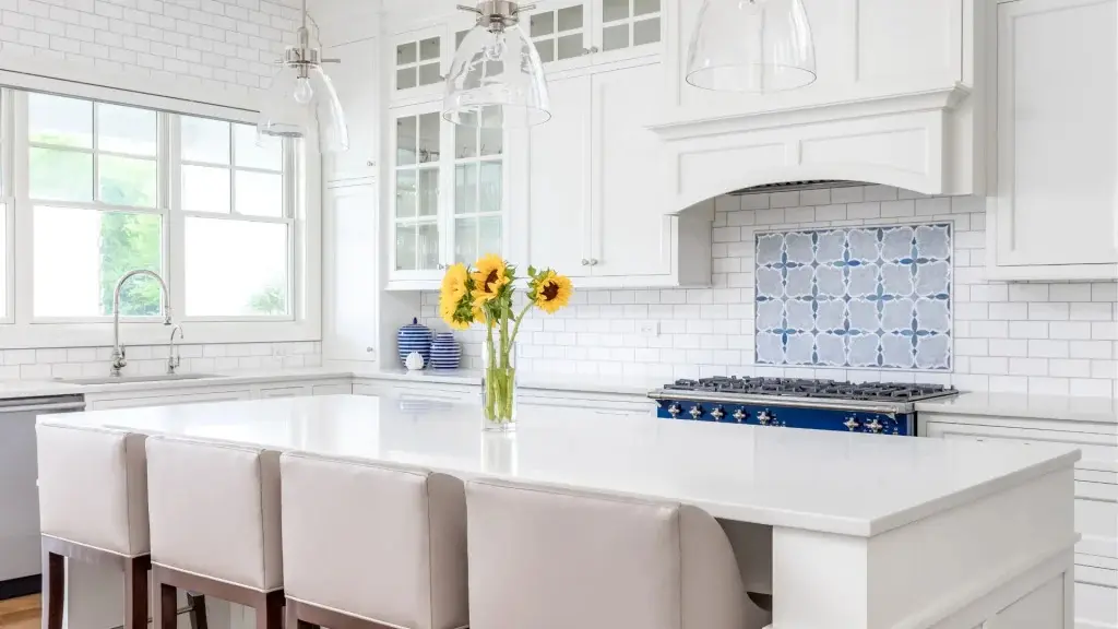 Modern Kitchen Backsplash Ideas in Alide, VA 6 Modern white kitchen with a blue patterned tile backsplash and sunflowers on a large island
