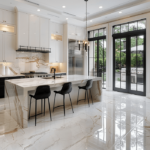 Modern luxury kitchen with a waterfall marble island, natural stone tile flooring, black chairs, and floor-to-ceiling windows.
