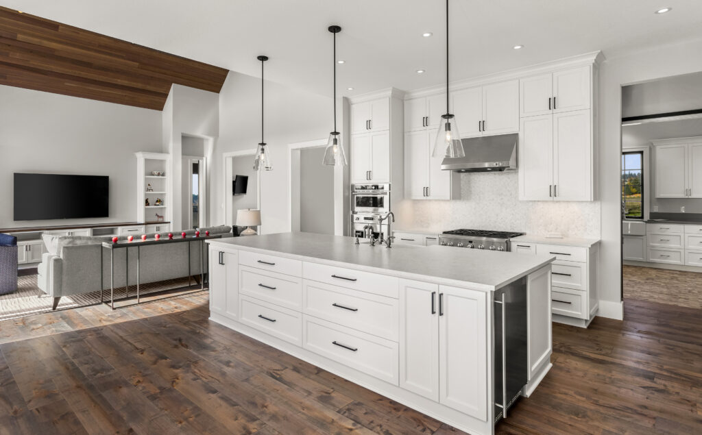 The Ultimate Guide to Kitchen and Floor Tiles 8 Modern open-concept kitchen featuring white shaker cabinets, stainless steel appliances, a large island, and dark hardwood flooring