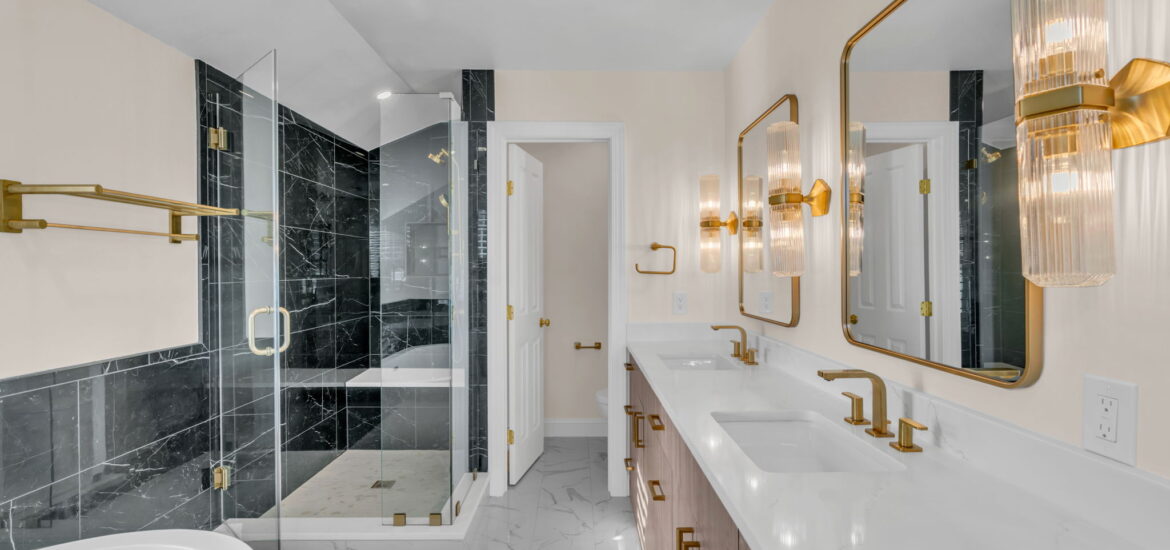 Luxurious modern bathroom with gold fixtures and black marble shower