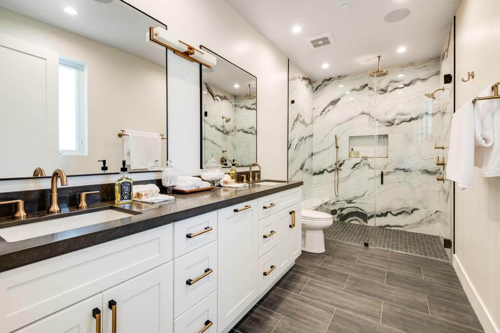 Elegant bathroom with black and white marble shower and gold fixtures