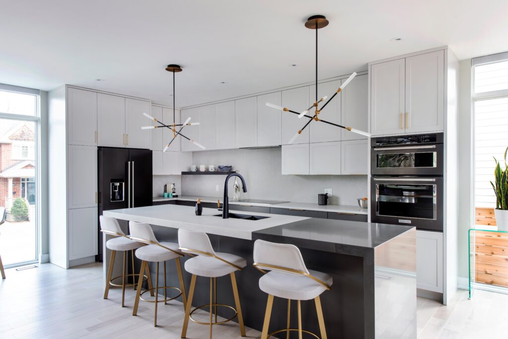 Modern kitchen with matte black island, minimalist lighting, and sleek white cabinetry