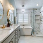 Elegant bathroom with round mirrors, freestanding tub, and marble shower