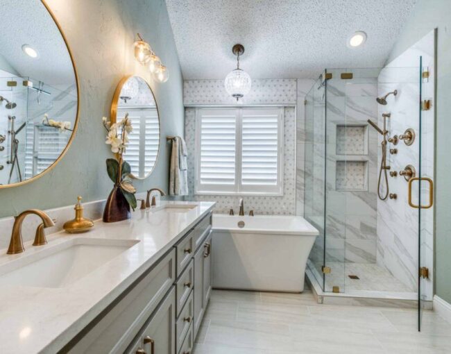 Elegant bathroom with round mirrors, freestanding tub, and marble shower