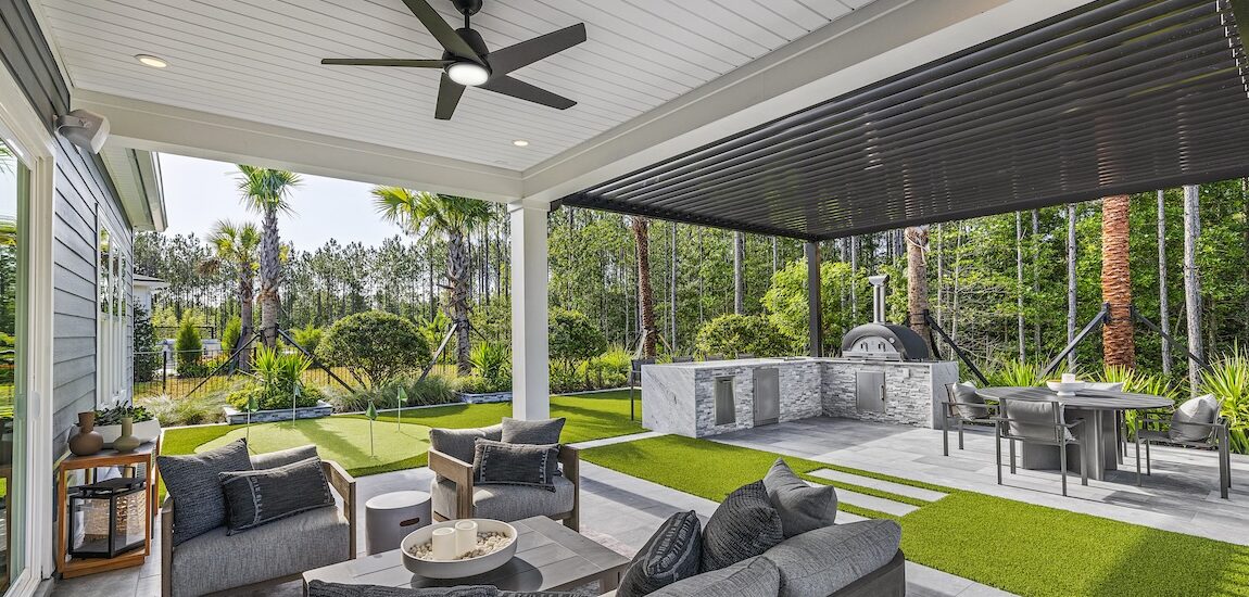 Modern covered patio with outdoor kitchen, lounge seating, and putting green