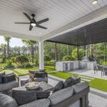 Modern covered patio with outdoor kitchen, lounge seating, and putting green