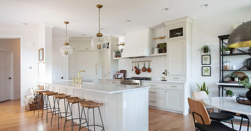 Bright farmhouse-style kitchen with marble island and wooden stools
