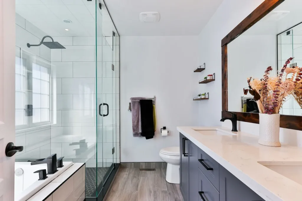 Modern bathroom interior with glass shower, double vanity, and decorative elements