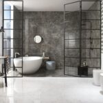 Modern bathroom featuring a freestanding oval tub, black-framed glass dividers, and dark marble accent wall