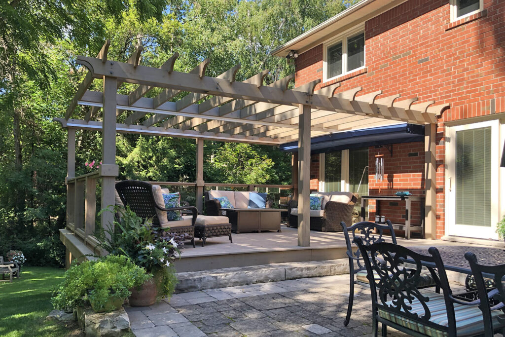 Backyard deck with pergola, retractable canopy, and cushioned seating area