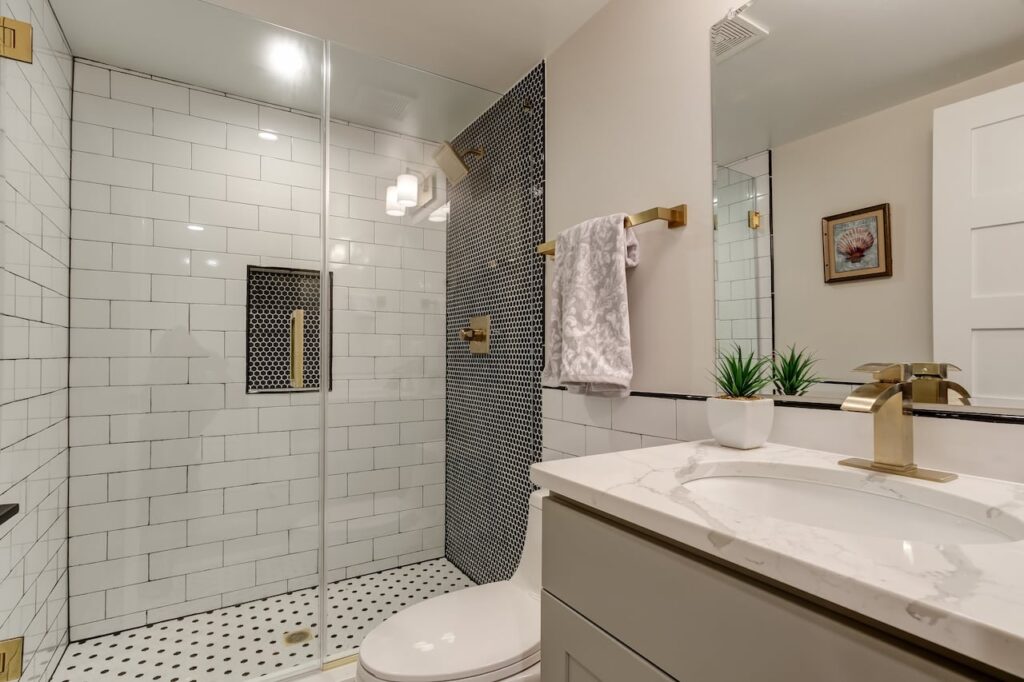 Stylish small bathroom with gold fixtures and patterned tile accents