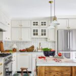 White kitchen with tile flooring, large island, and stainless steel appliances