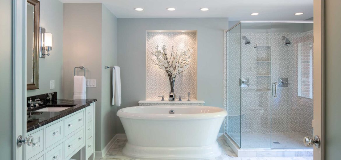 Luxurious bathroom with freestanding tub, marble flooring, and glass-enclosed shower.