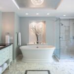 Luxurious bathroom with freestanding tub, marble flooring, and glass-enclosed shower.