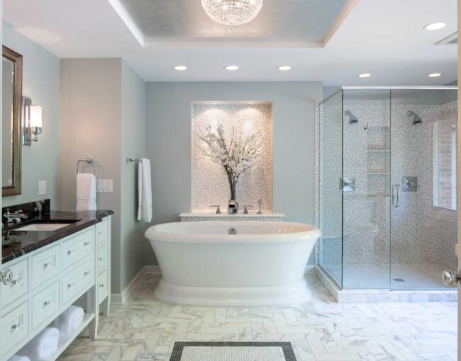 Luxurious bathroom with freestanding tub, marble flooring, and glass-enclosed shower.