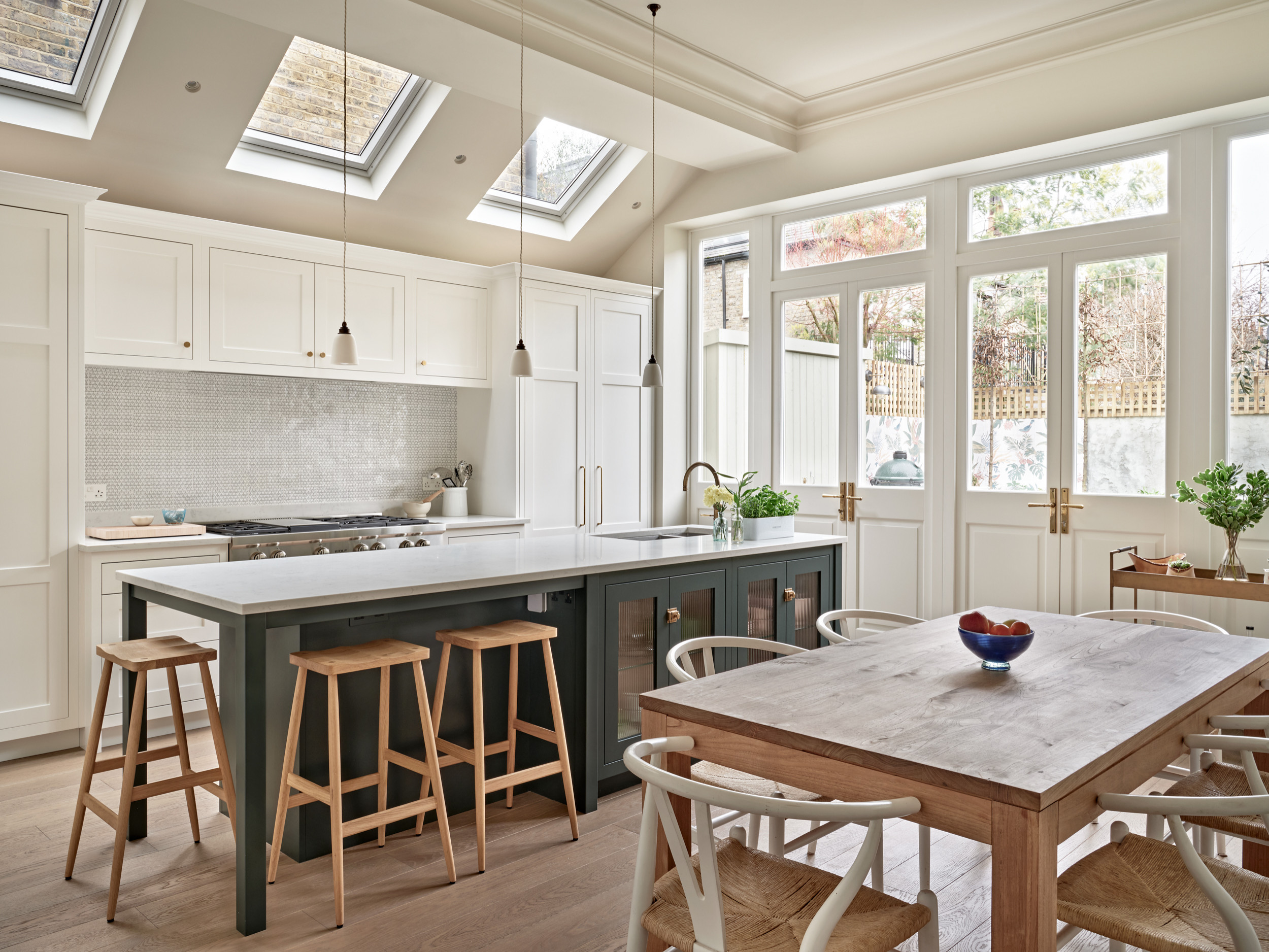 Bright contemporary kitchen with skylights, a large island, and natural wood dining furniture.