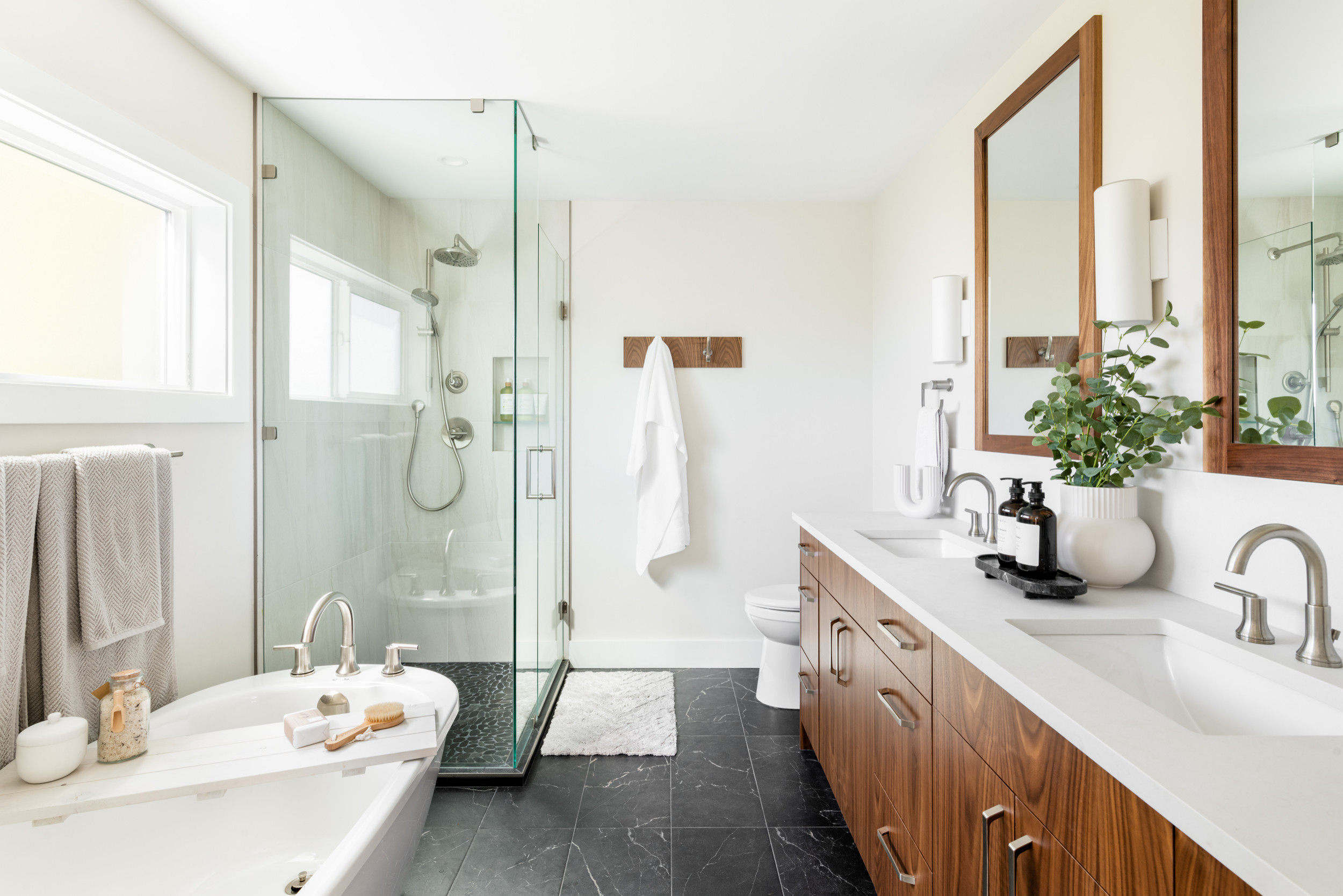 Contemporary bathroom with freestanding bathtub, glass shower enclosure, and wood vanity.