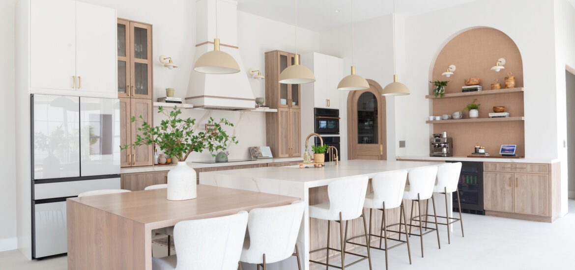 Spacious modern kitchen with wood accents, white cabinetry, and large island seating.
