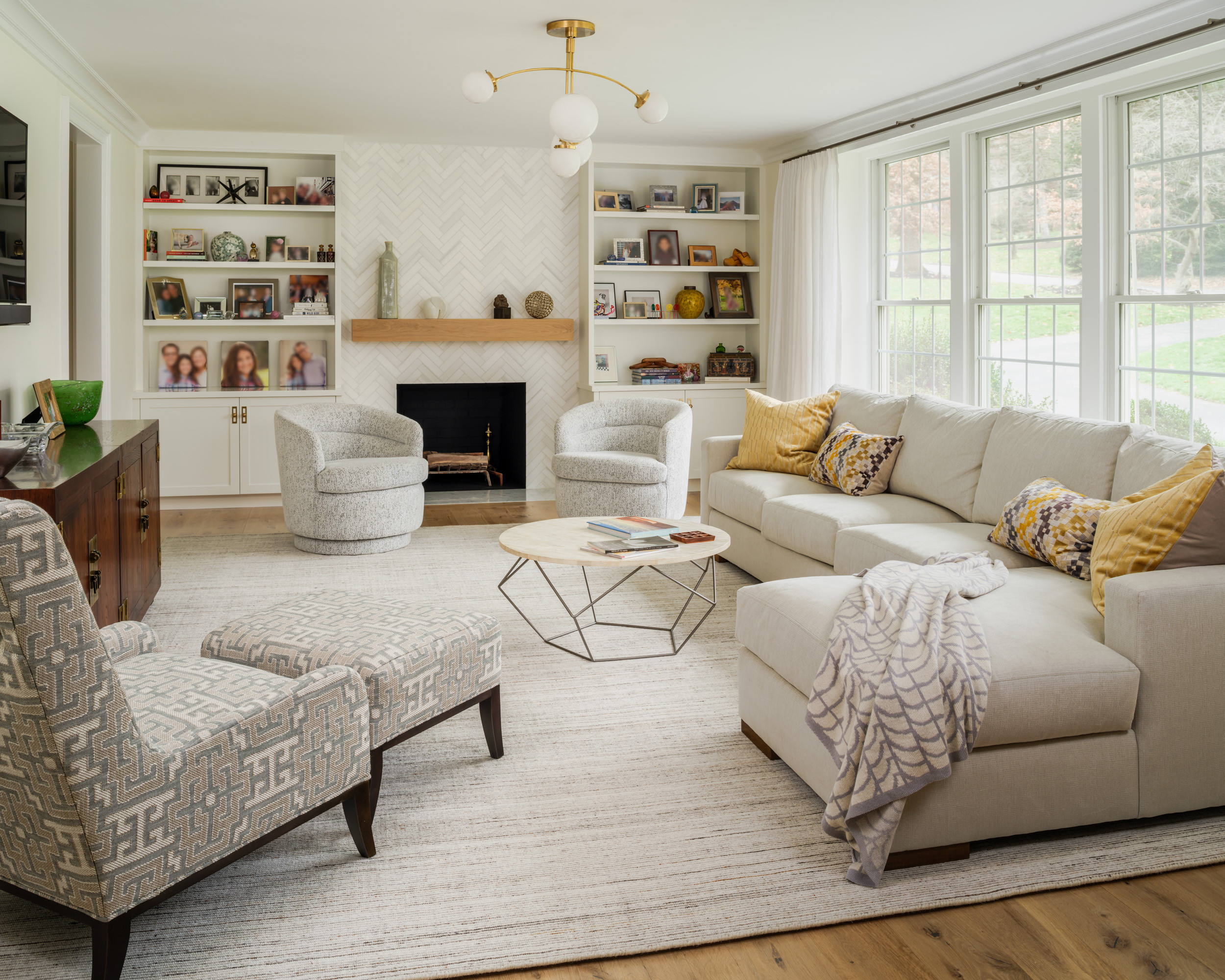 Bright modern living room with sectional sofa, fireplace, and built-in bookshelves