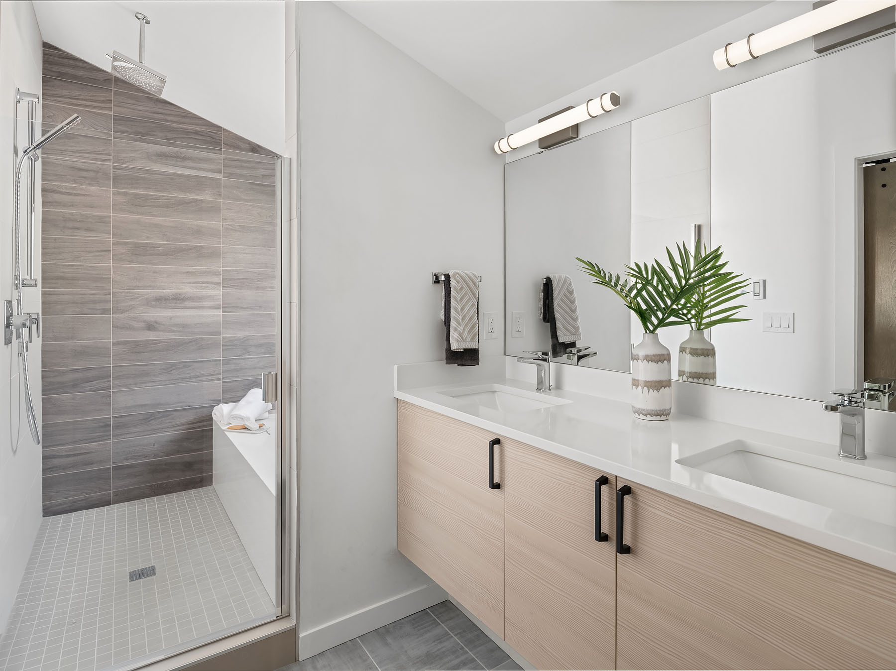 Modern bathroom with double vanity, large mirror, and walk-in shower.