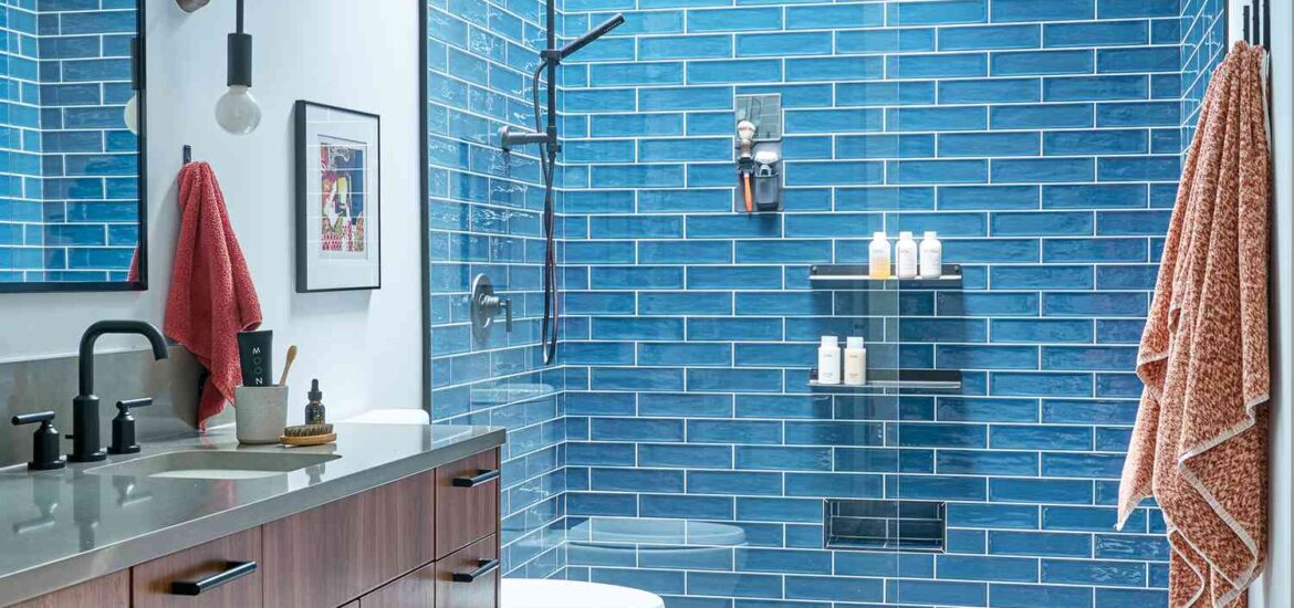 Modern bathroom with blue subway tile shower and floating wood vanity.