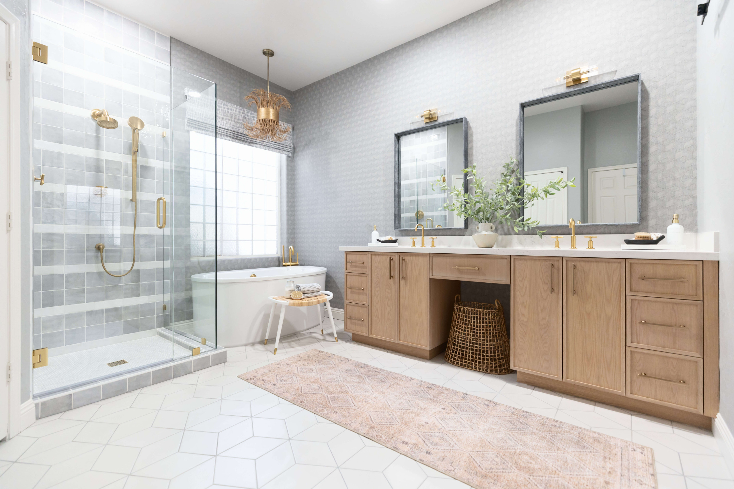 Modern bathroom with glass-enclosed shower, freestanding bathtub, wooden vanity, and gold fixtures.
