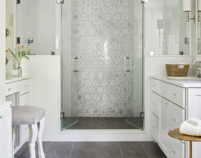 Elegant bathroom with glass-enclosed shower and hexagon tile accent wall.