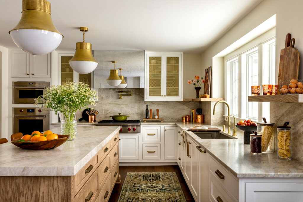 Warm kitchen with gold accents, marble countertops, and natural wood island.