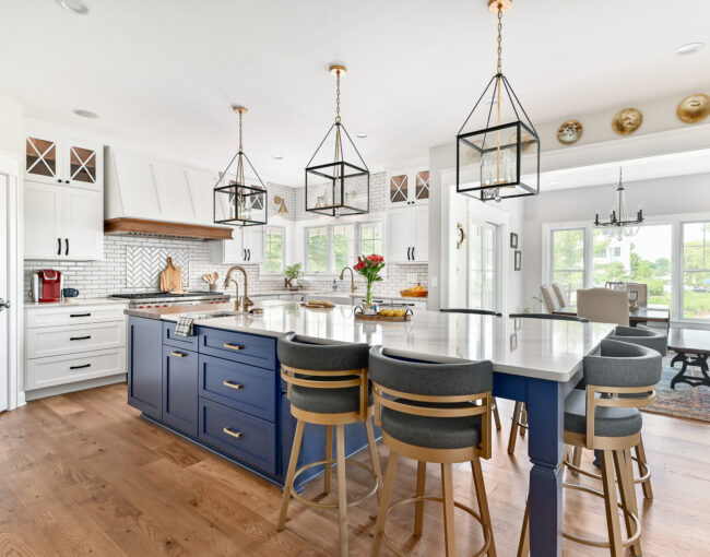 Bright kitchen with blue island cabinets, white cabinetry, and gold accents.