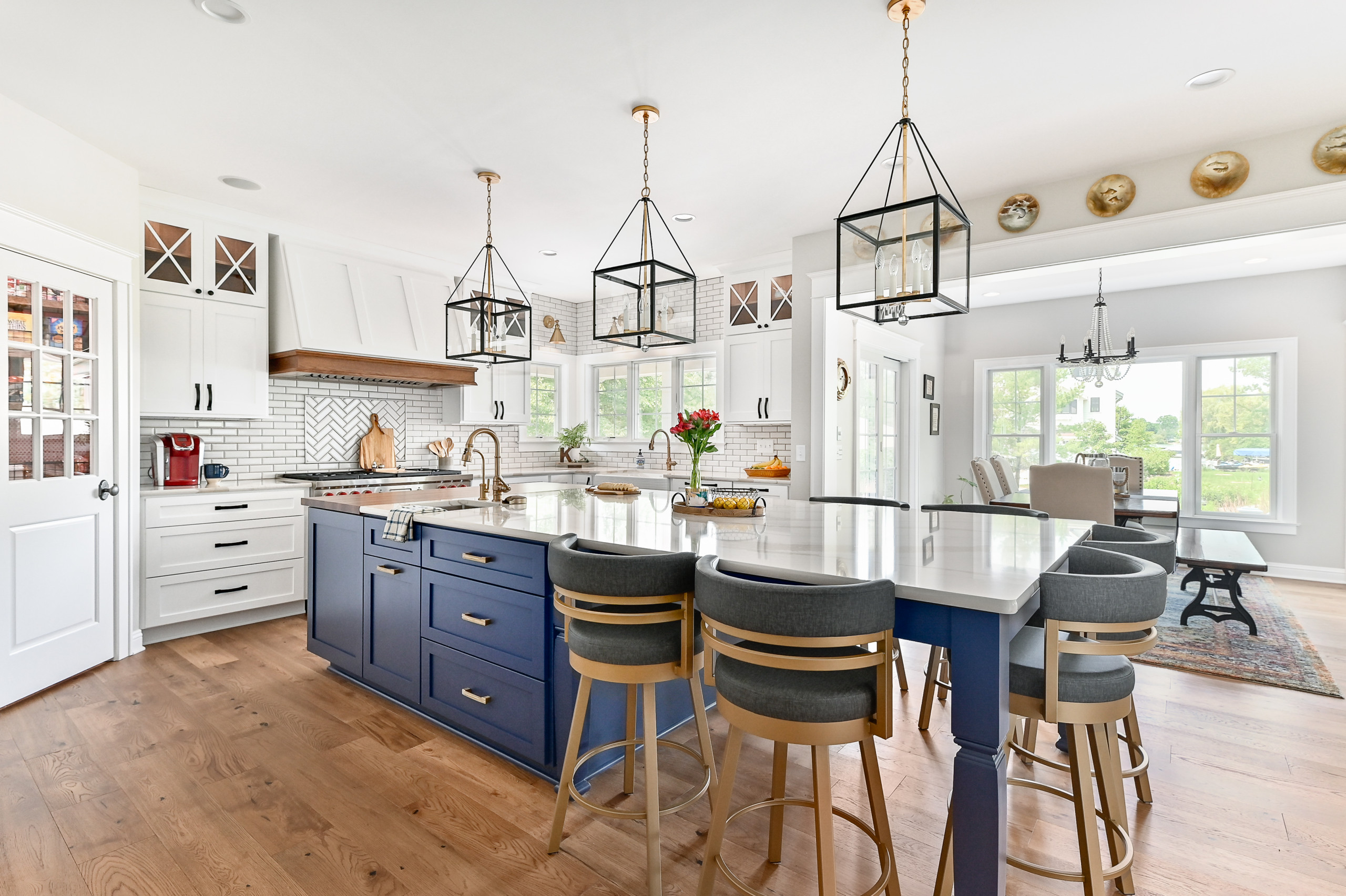 Bright kitchen with blue island cabinets, white cabinetry, and gold accents.