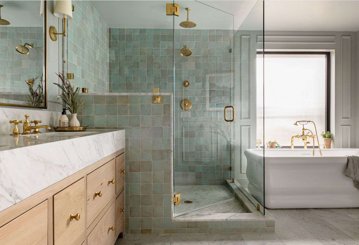 Luxurious bathroom with green square tile shower, marble vanity, and gold fixtures.