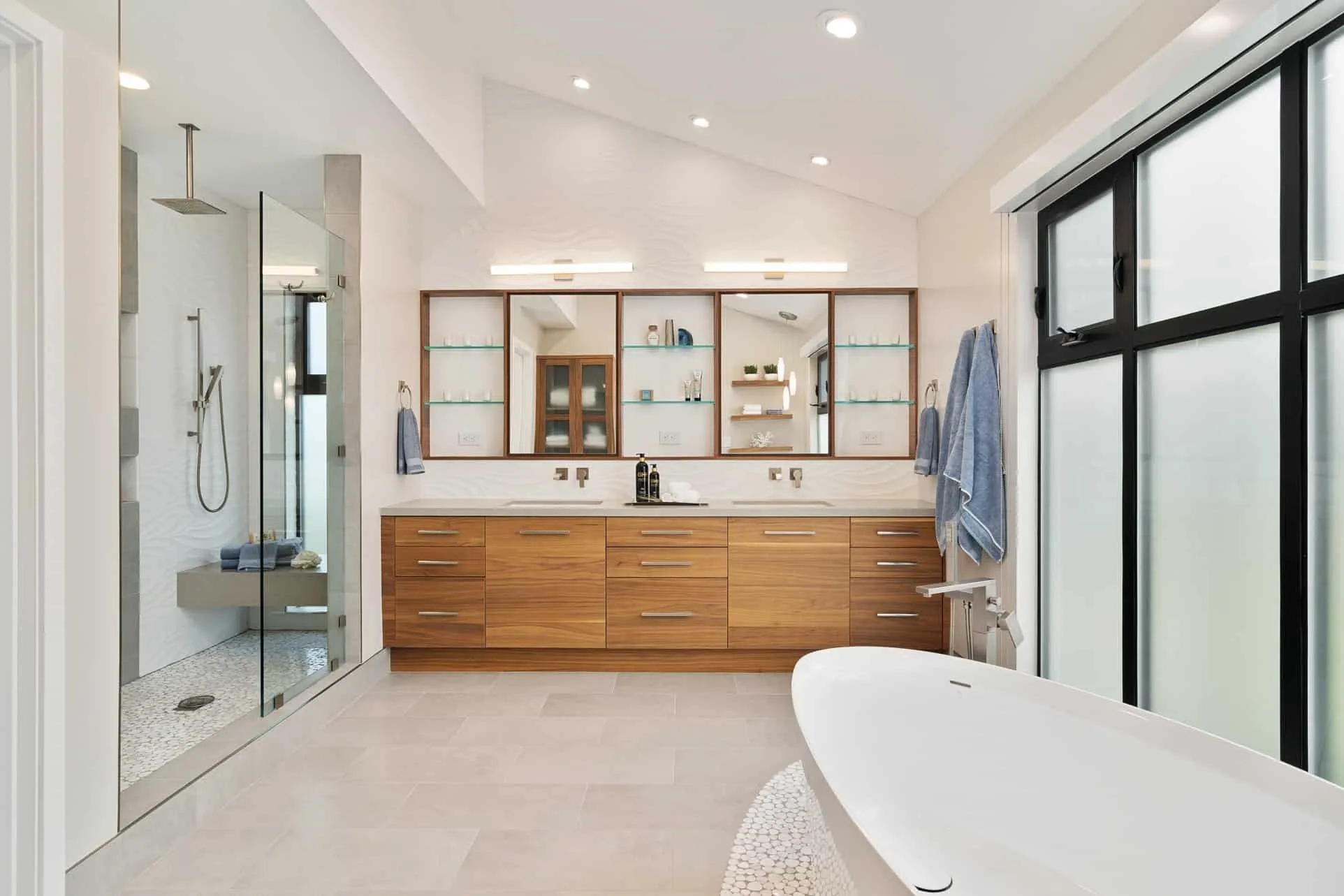 Modern bathroom with wooden vanity, freestanding tub, and walk-in glass shower