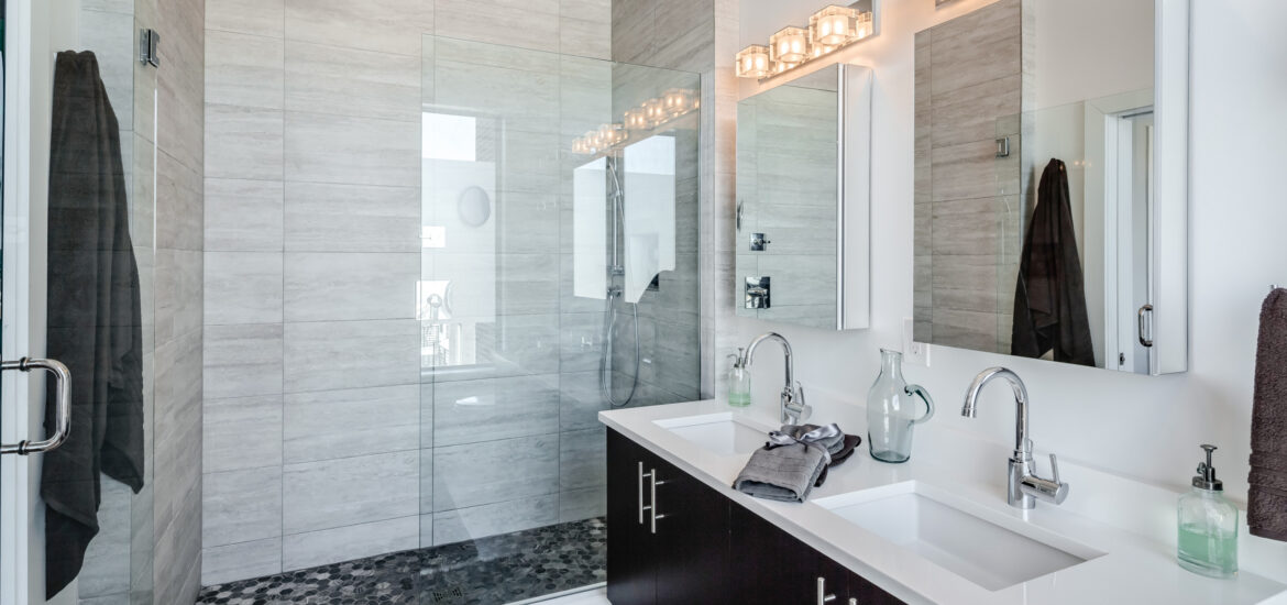 Contemporary bathroom with glass-enclosed shower, double vanity, and modern lighting.