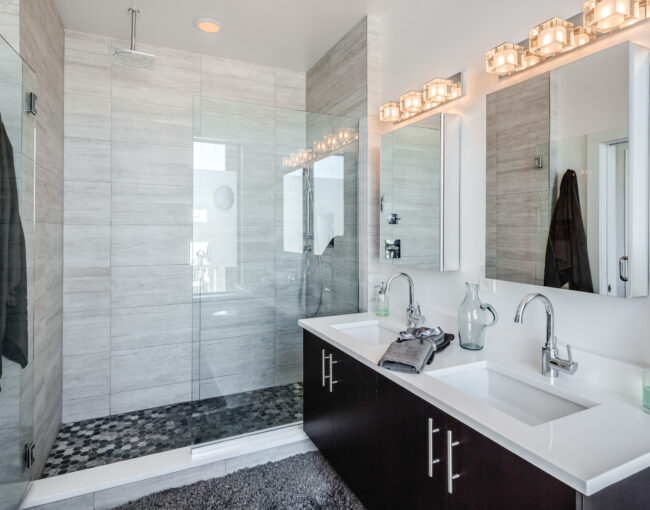 Contemporary bathroom with glass-enclosed shower, double vanity, and modern lighting.