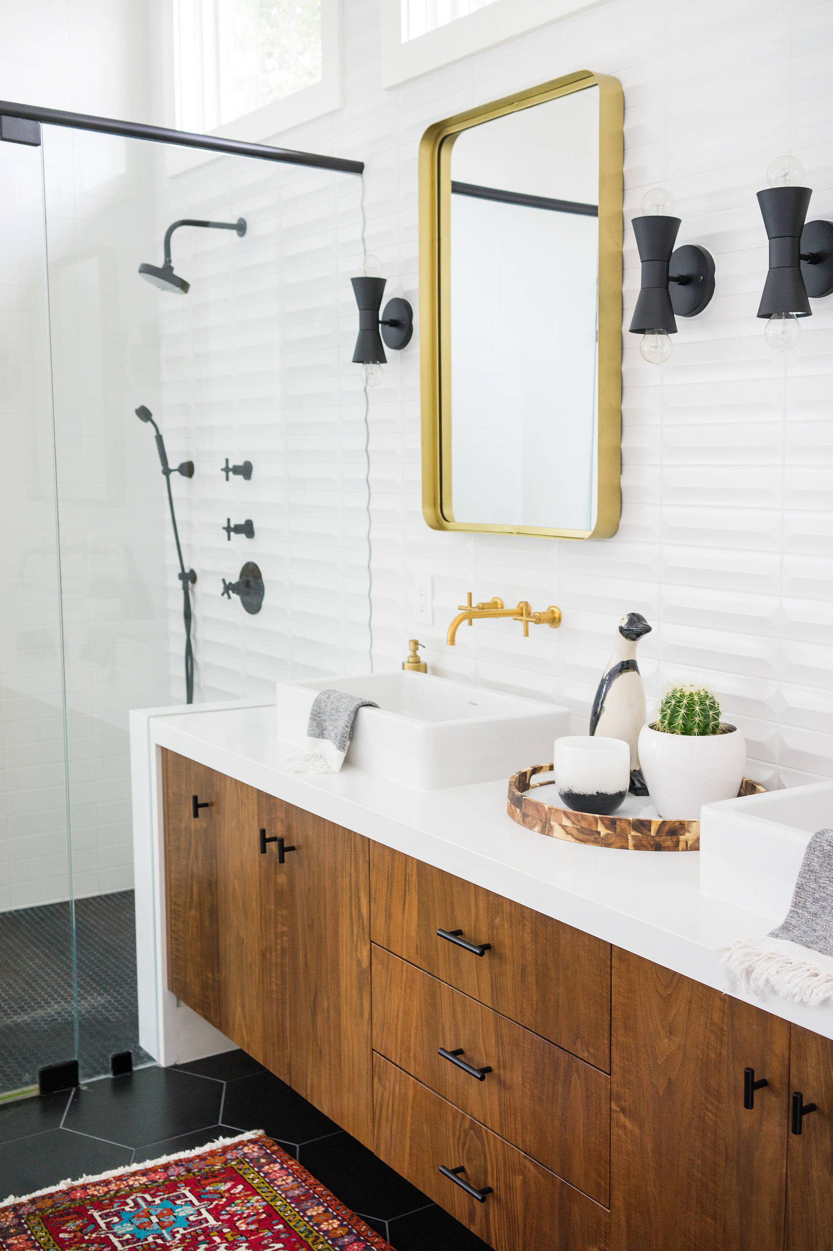 Modern bathroom vanity with wooden cabinets, gold fixtures, and black accents.