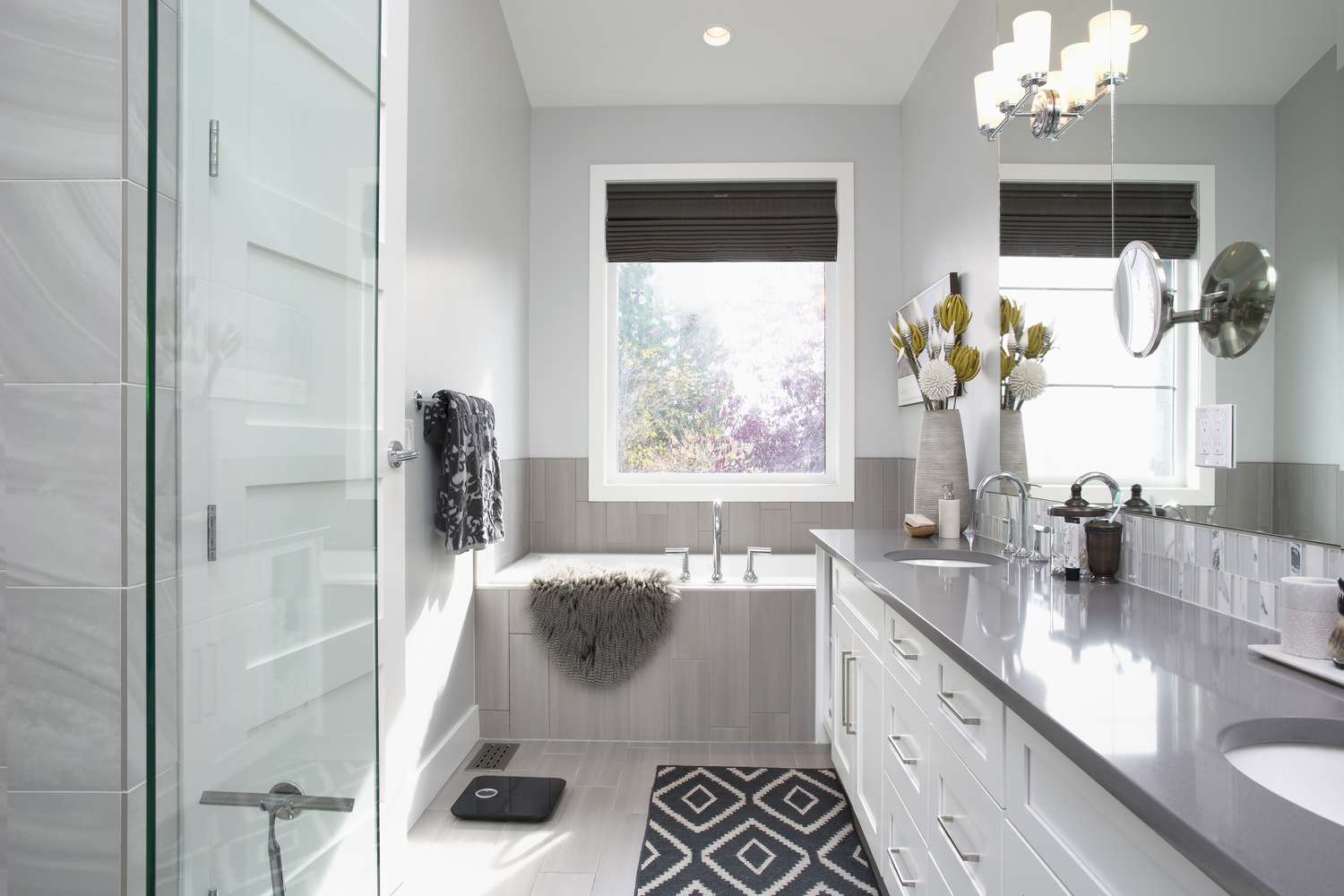 Elegant modern bathroom with double vanity, soaking tub, and large window.
