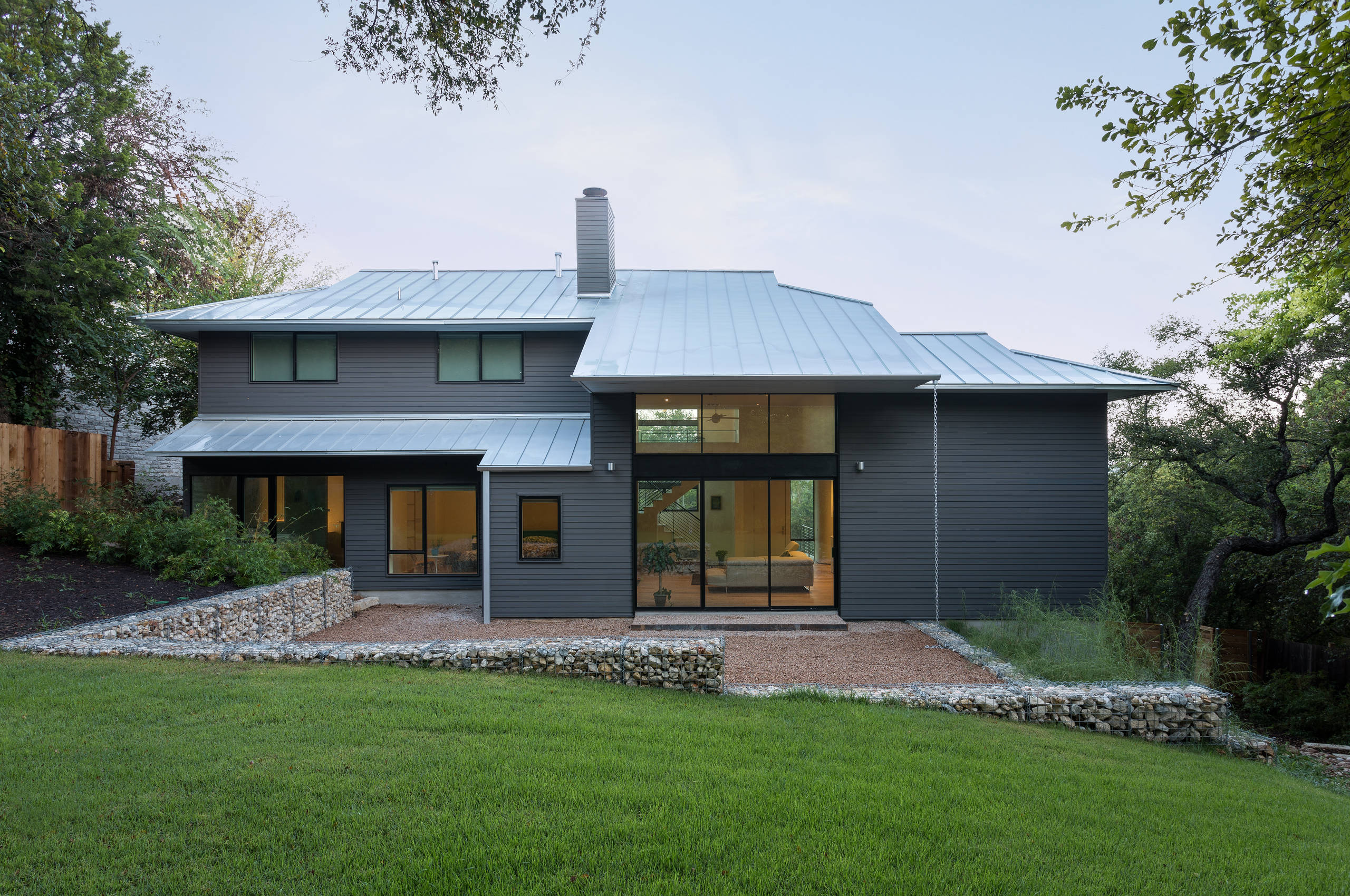 Modern remodeled home exterior with large windows and metal roof