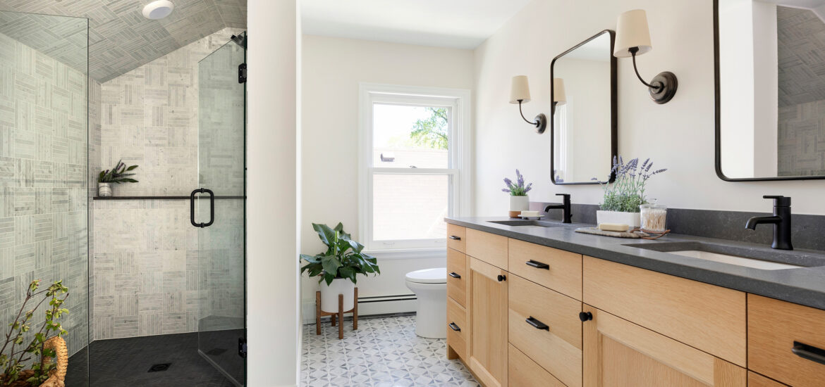 Bright bathroom with wood double vanity, glass shower, and patterned tile floor.